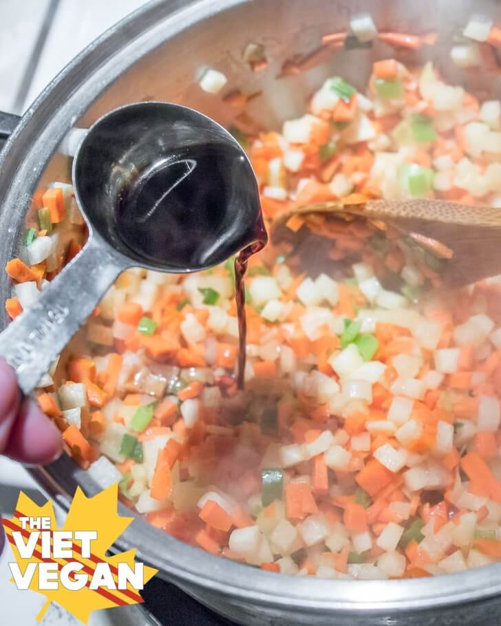 Adding soy sauce to the cooked vegetable filling