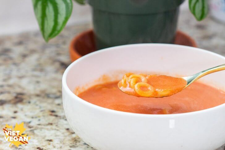 Spaghetti O noodles in a spoon over a bowl of soup