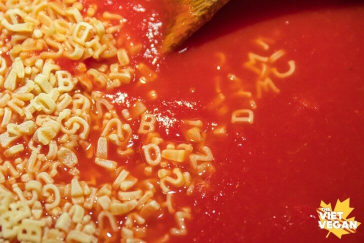 alphabet pasta in a pot about to be mixed into tomato soup