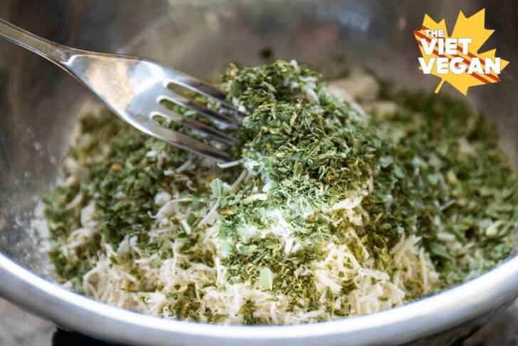 mixing herbs in a bowl with flour and a fork