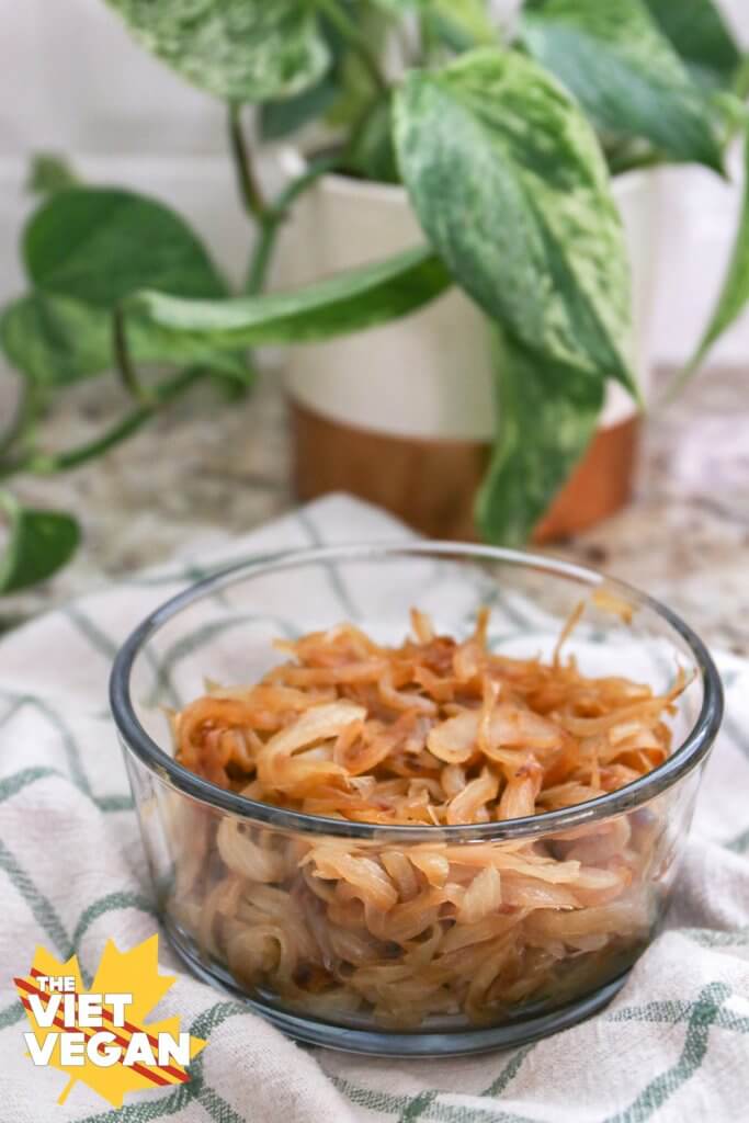 caramelized onions in a glass container on top of a tea towel, 