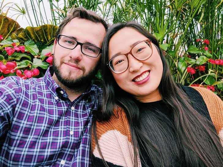 Eddie and Lisa sitting in front of some foliage