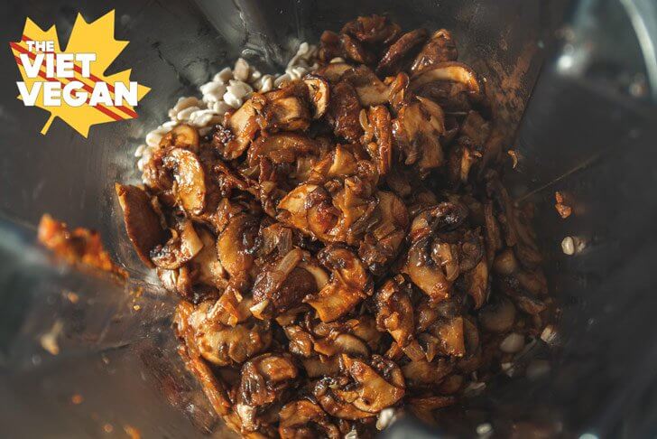 Cooked mushrooms on top of soaked sunflower seeds in a blender jar 