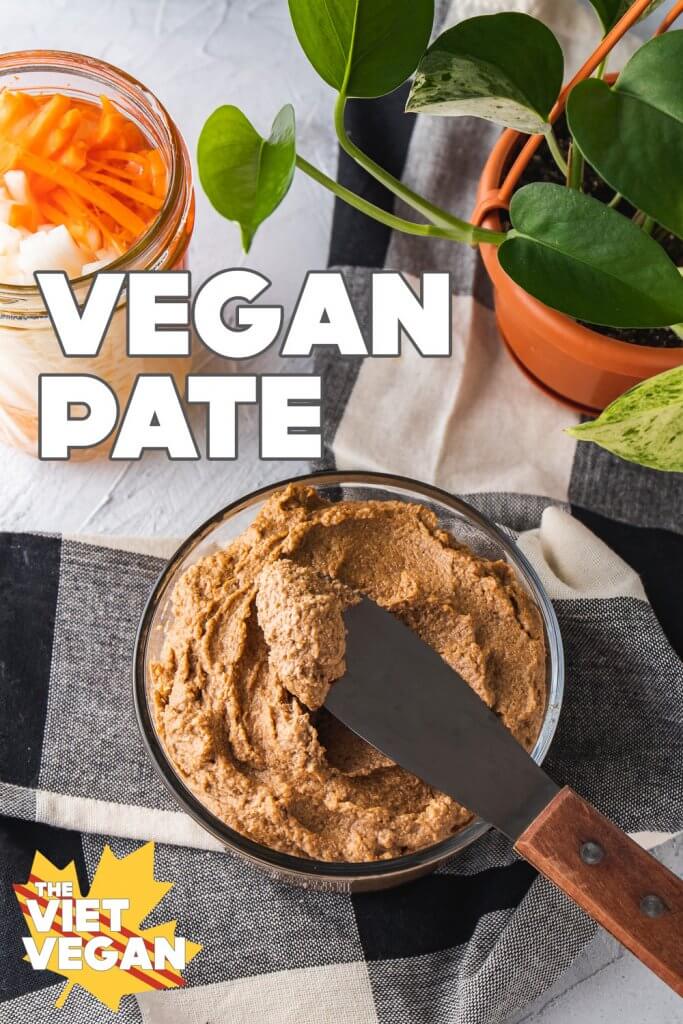 vegan pate on a black and white tablecloth with pickled carrots and daikon and a pothos