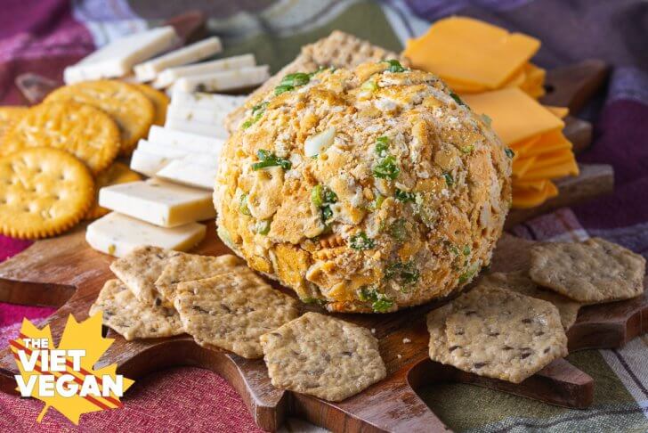 Vegan Cheddar Cheese Ball on a cheese board surrounded by vegan cheese & crackers