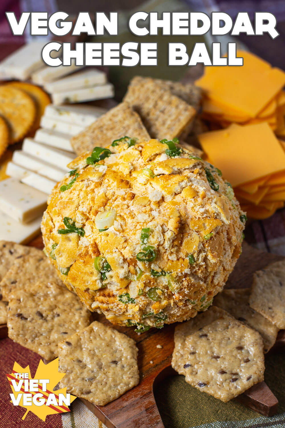 Vegan Cheddar Cheese Ball on a cheese board surrounded by vegan cheese & crackers