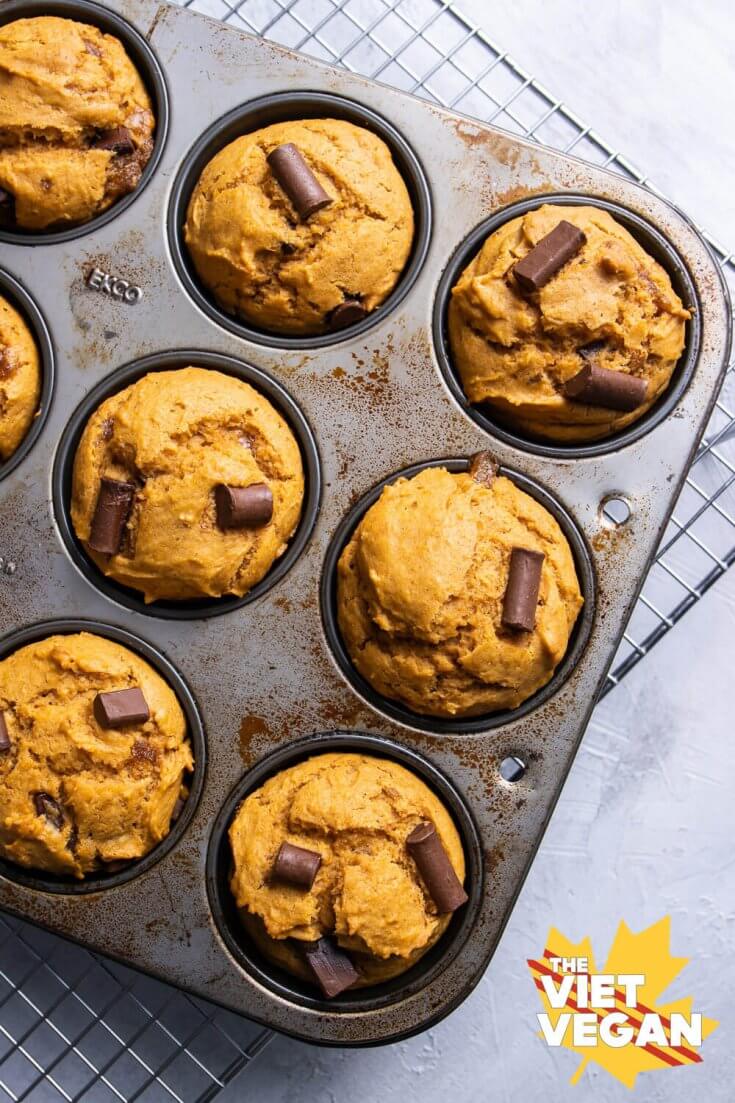 baked muffins in a baking pan on a cooling rack, on a white surface