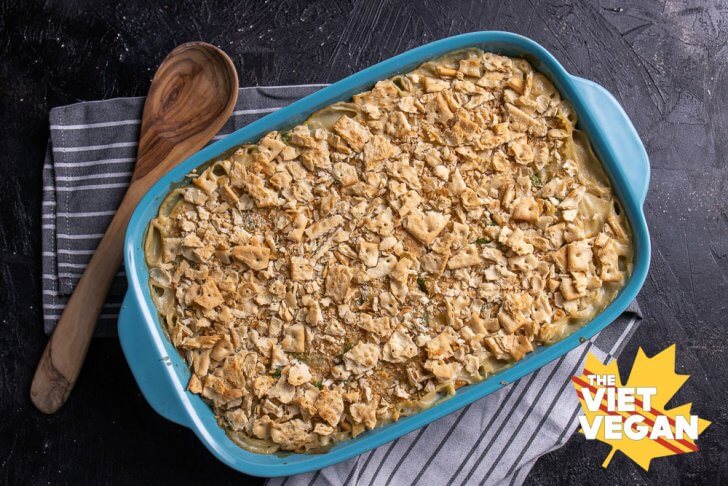 overhead shot of casserole dish with saltine crust on a tea towel with a wooden spoon