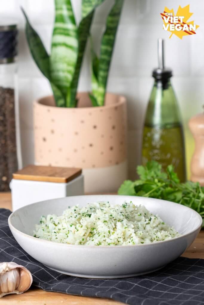 finished rice dish on a tea towel, with cilantro and a snake plant in the background