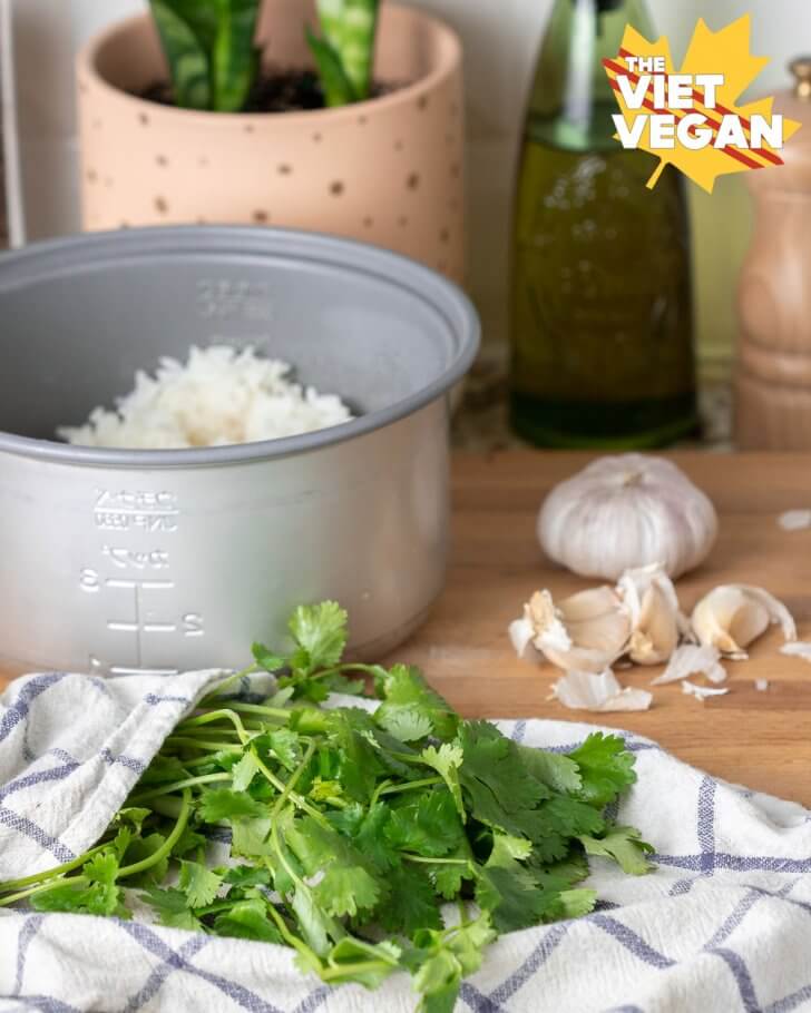 cooked rice, garlic, and cilantro on a cutting board