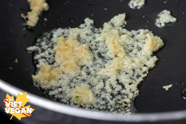 pressed garlic frying in oil in a large wok