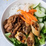vermicelli bowl with spring rolls, noodles, pickled carrots and daikon, cucumber and lettuce