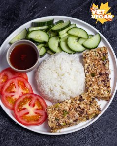 meatloaf slices on a plate with a mound of white rice, cucumber, sliced tomato, and sauce, from above