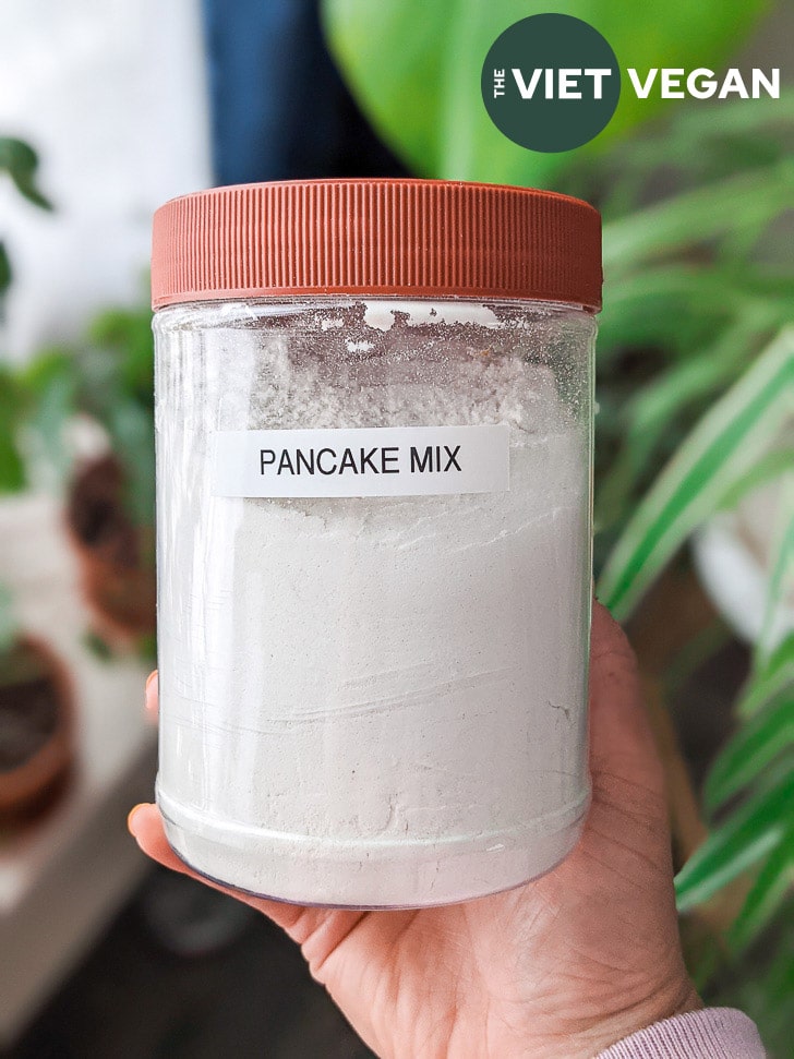 dry vegan pancake mix in a tub with "pancake mix" label on it