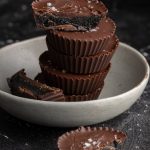 black sesame butter cups stacked, with three halves split and placed around the stack.