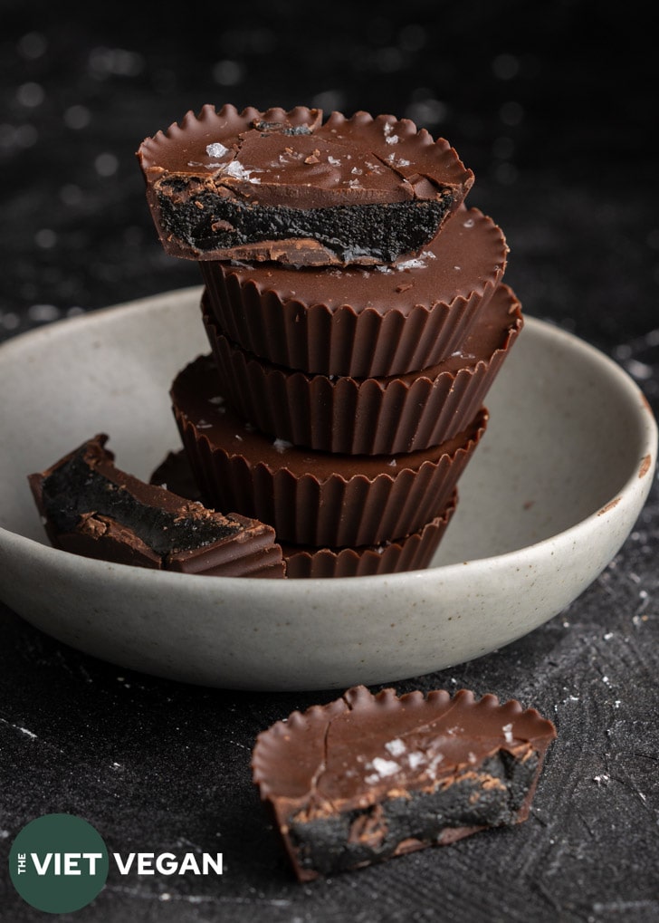 black sesame butter cups stacked, with three halves split and placed around the stack.