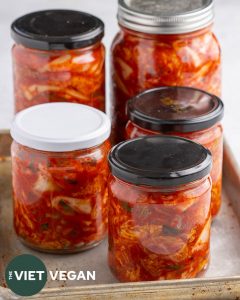 5 jars of kimchi fermenting on a baking tray