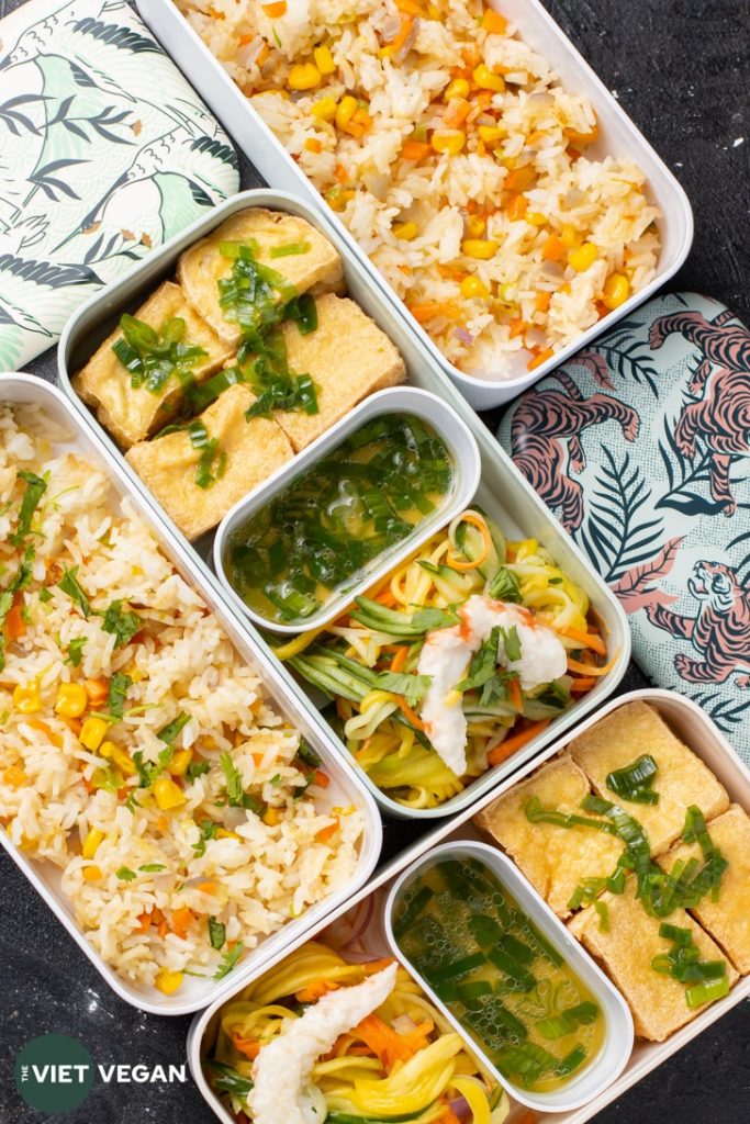 Bento Box from above with fried tofu, sauce, green mango salad, and fried rice layers