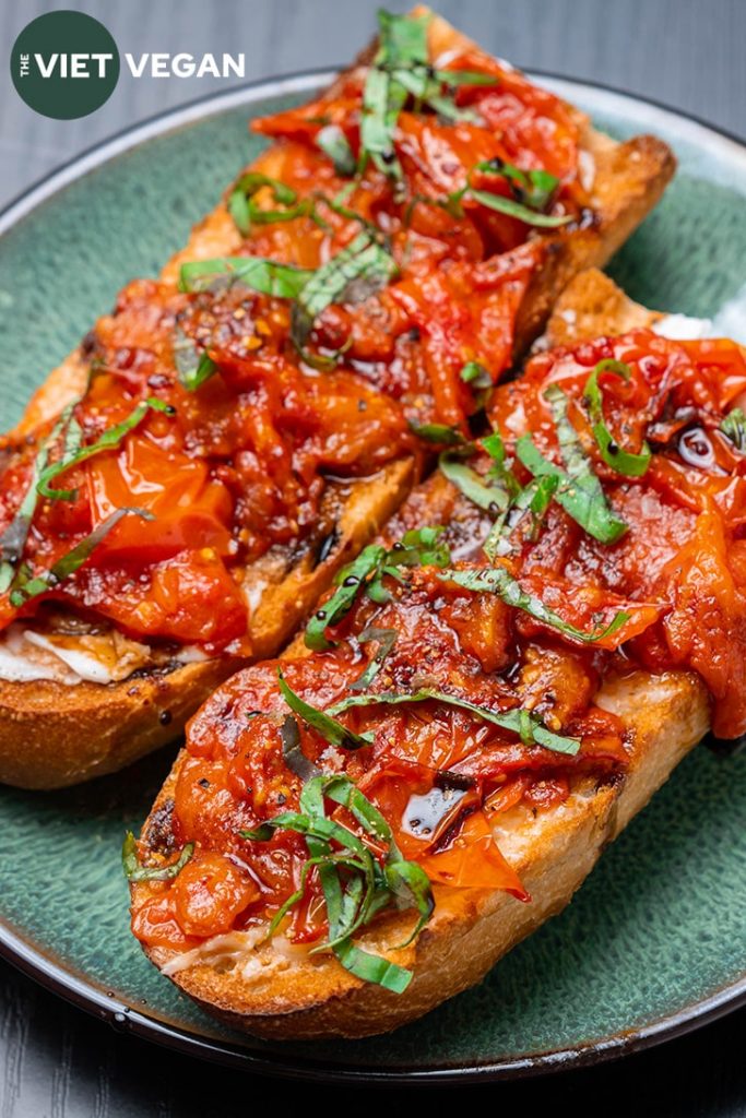 toast close up with garlic tomato confit on a green plate