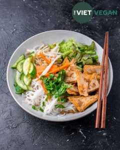 lemongrass tofu vermicelli noodle bowl with cucumber, lettuce, and pickled carrots and daikon for topping