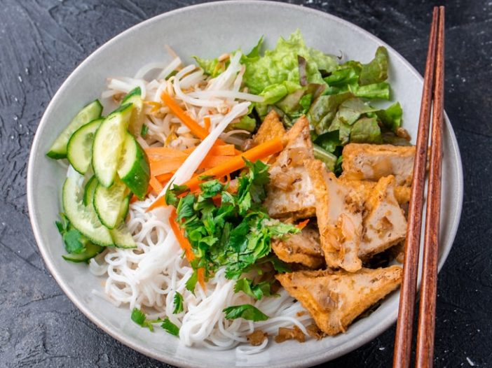 lemongrass tofu vermicelli noodle bowl with cucumber, lettuce, and pickled carrots and daikon for topping