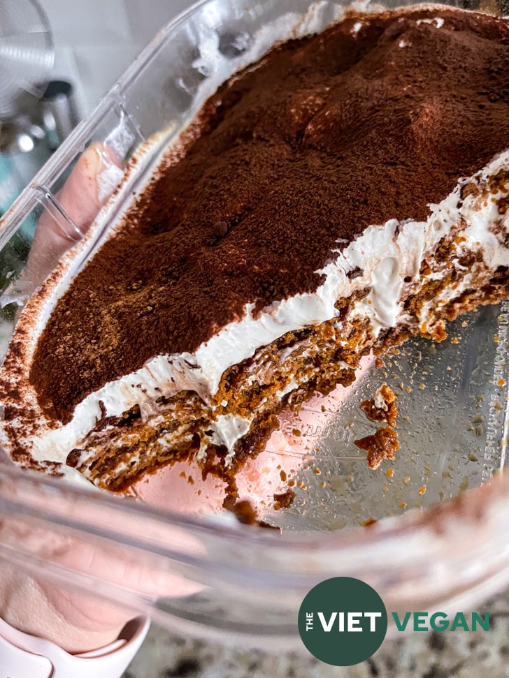 Partially eaten tiramisu, exposing the layers of cookie and cocowhip