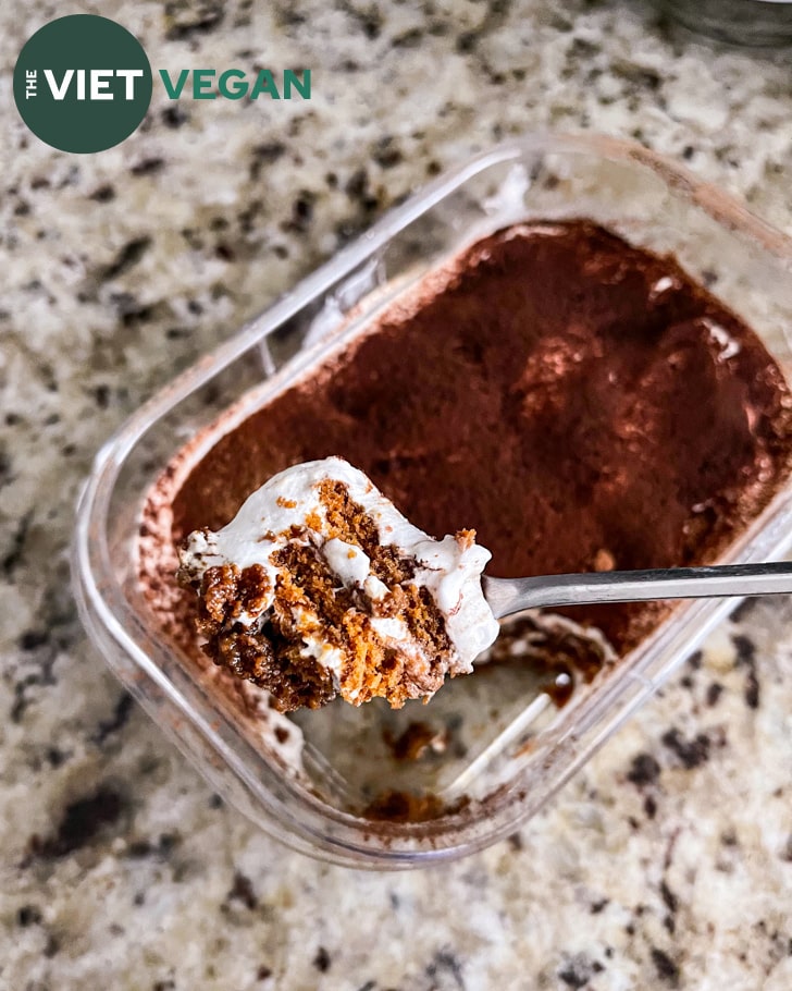 A spoonful of vegan biscoff tiramisu, with the layers of biscuit and cocowhip visible