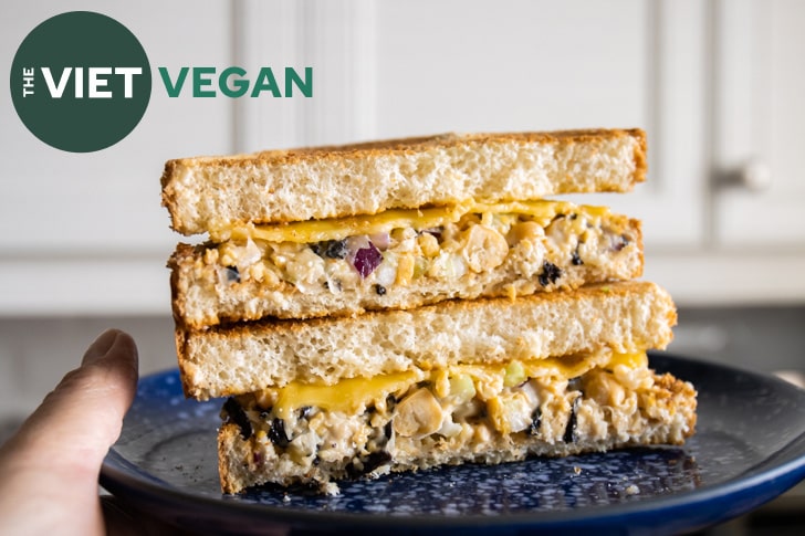 chickpea tuna sandwich cut in half and stacked on a blue plate, closeup