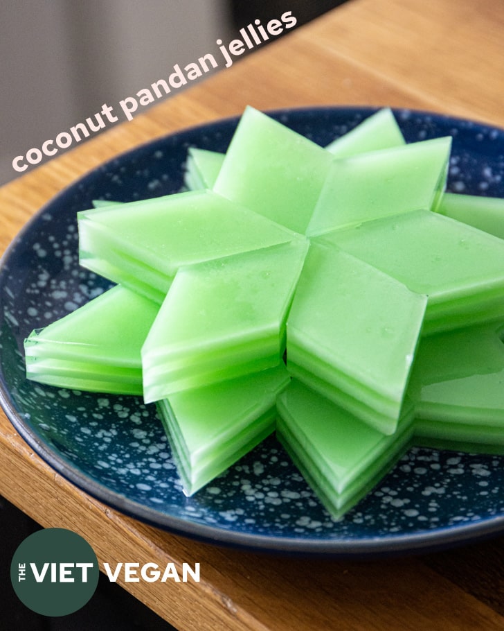 diamond shaped coconut pandan jellies arranged on a blue white speckled plate