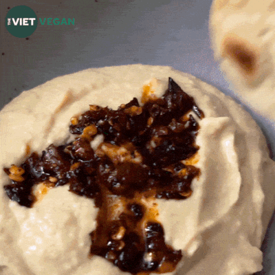 animated GIF of a cracker being dipped into hummus to show the creamy texture