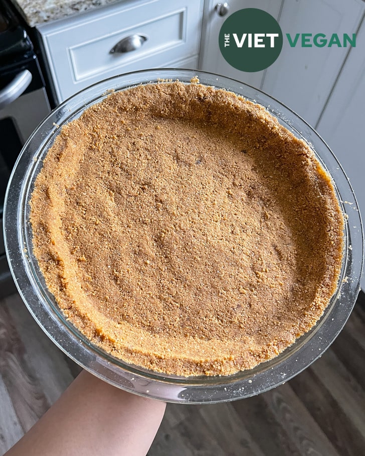 graham cracker crumb crust in a glass pan, before baking