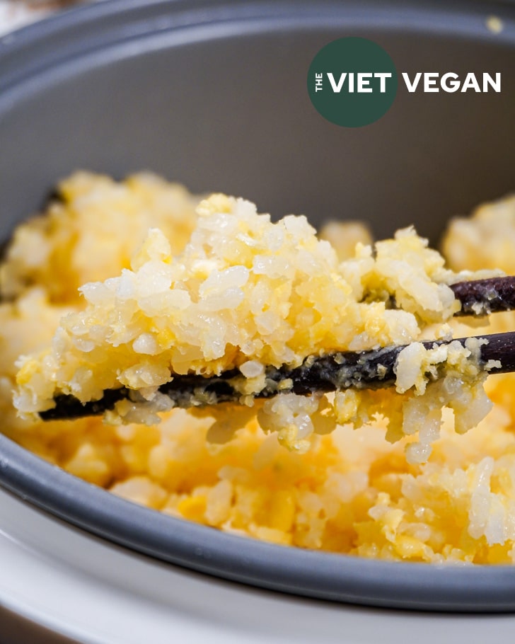 sticky rice in the rice cooker, held in some chopsticks for a closer look