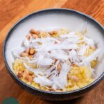 Sticky rice in a bowl with peanuts, sesame seeds and fresh coconut meat