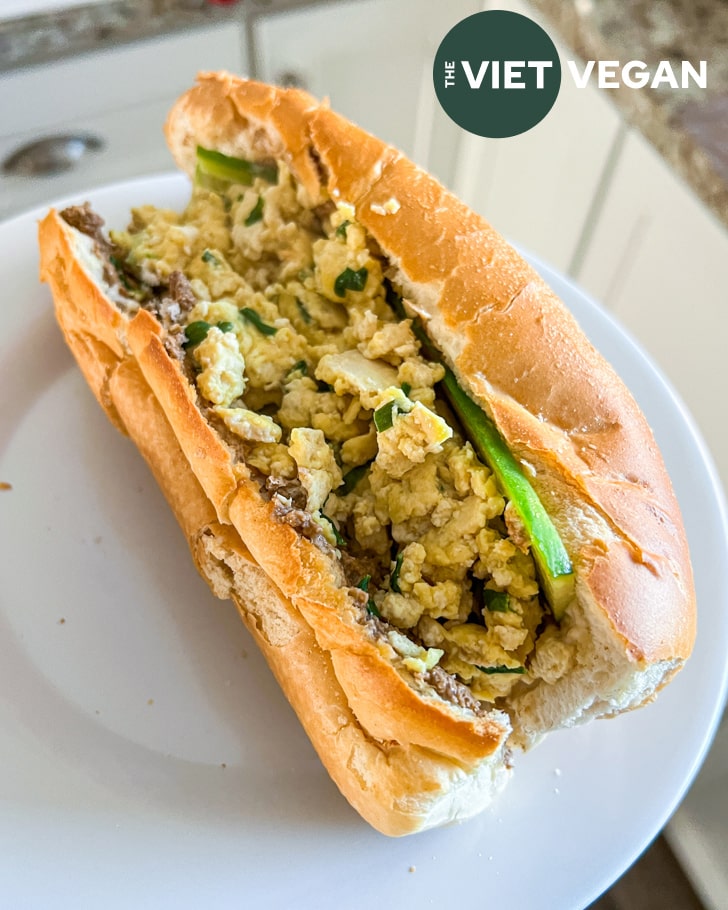 vietnamese egg scramble in a banh mi bun on a white plate