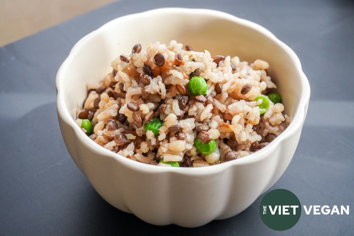 Horizontal shot of a scalloped bowl filled with rice with lentils, barley and peas