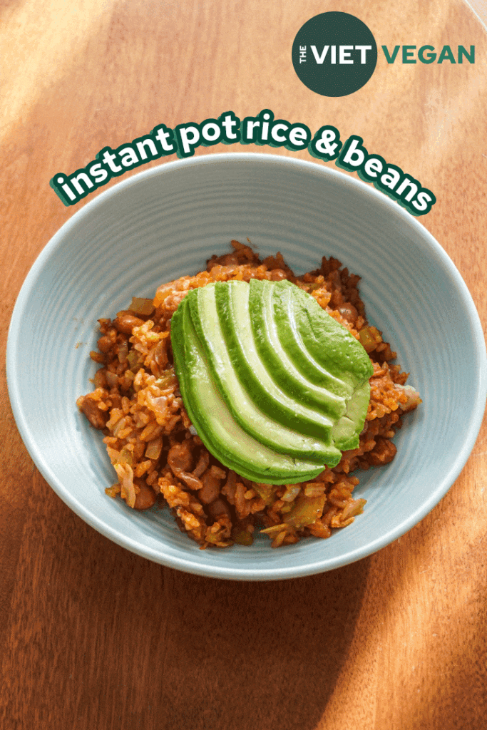 rice and beans in a blue bowl with avocado fanned on top