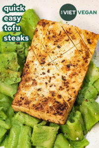 close up of quick easy tofu steak on a bed of green creamy pasta