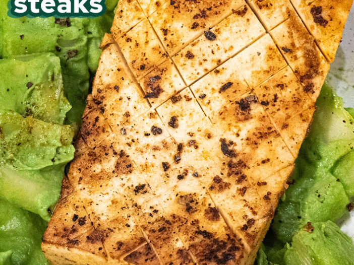 close up of quick easy tofu steak on a bed of green creamy pasta