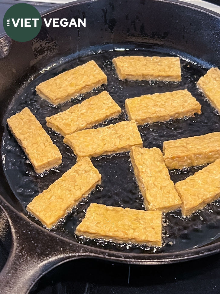 Shallow frying tempeh in a cast iron skillet