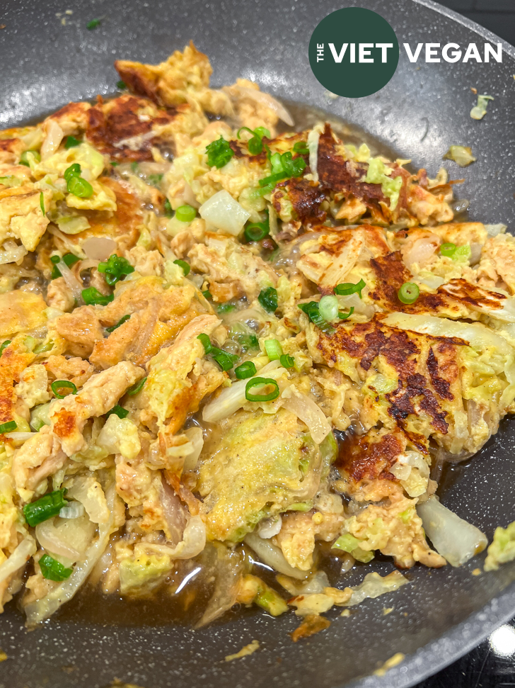 the oyakodon mixture of vegan chicken and plant-based egg in a pan with the dashi-based sauce.