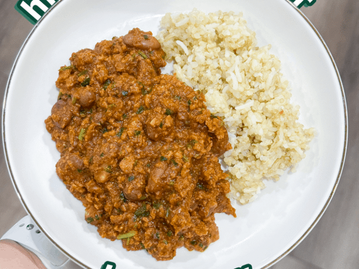 hidden bell pepper stew served with mixed rice in a shallow bowl.